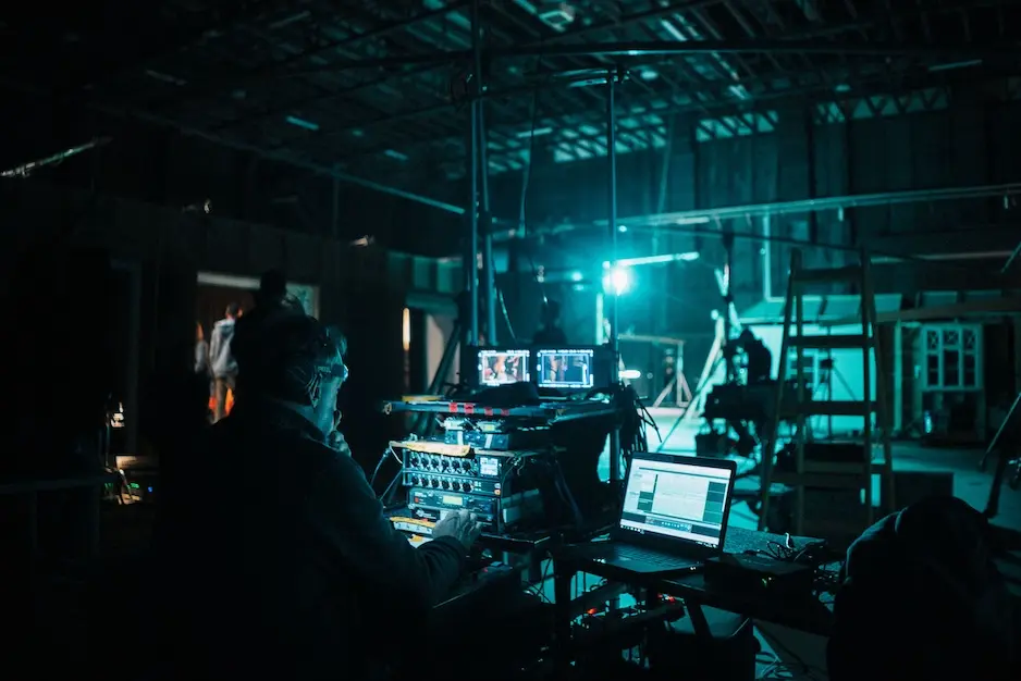 a sound designer sits near a microphone equalizer during a black box production
