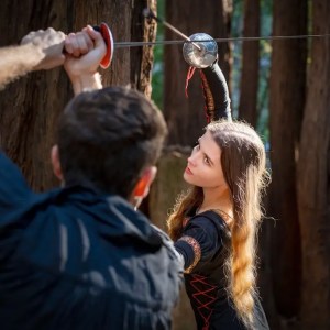 two actors engage in a choreographed fight with swords