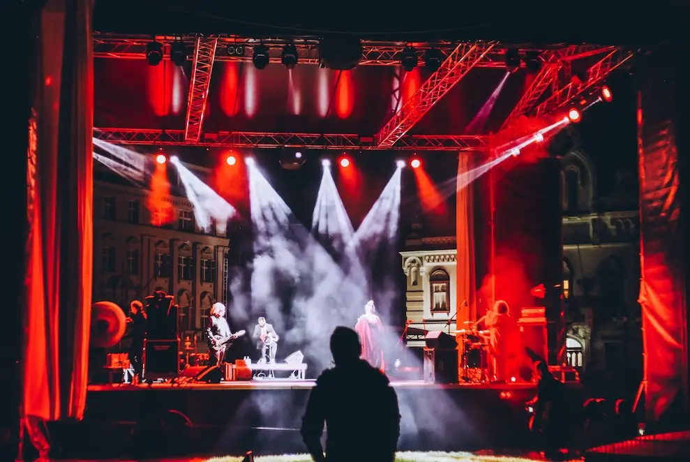 a producer looks at a concert rehearsal under stage lights from the house