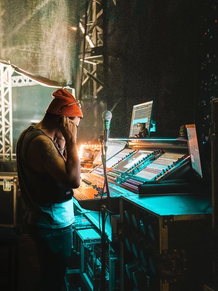 A sound designer wearing headphones mixes a show live.
