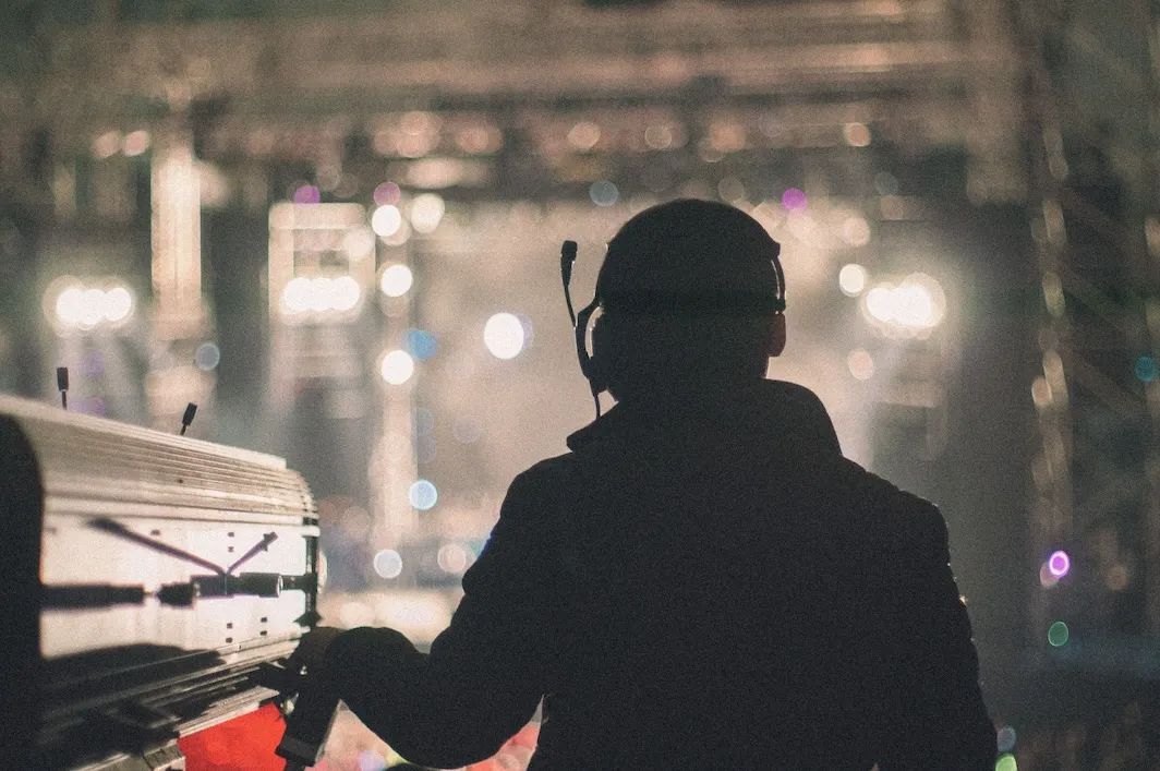 a pot operator watches a show while controlling a followspot.
