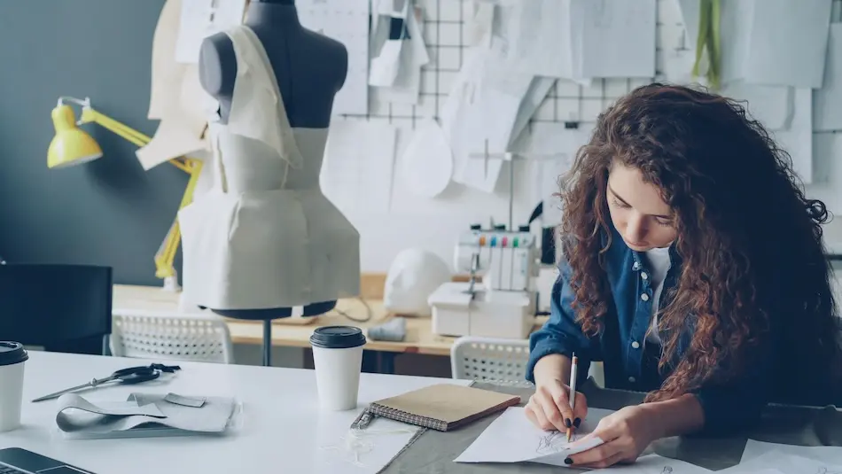 a costume designer mmakes notes in a costume shop.